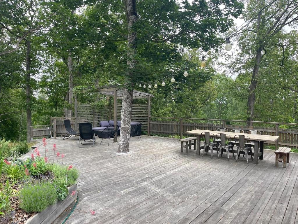 a wooden deck with tables and chairs and a gazebo at The Archipelago Hideaway in Vaxholm
