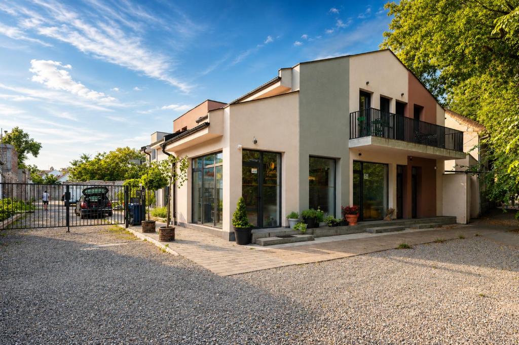 a white house with a fence and a driveway at Velora apartments in Subotica