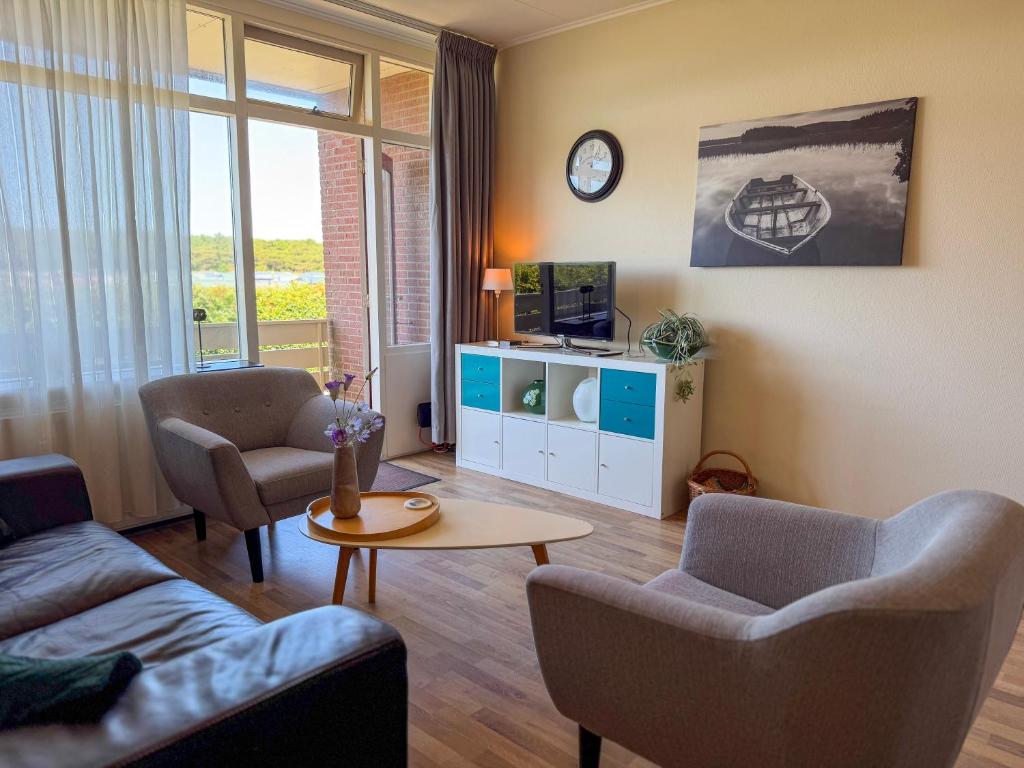 a living room with a couch and chairs and a table at Texel-De Koog 116 in De Koog