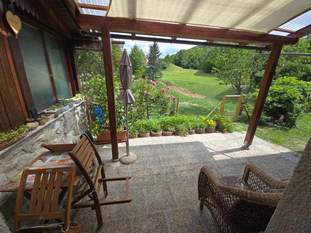 a patio with a table and chairs and an umbrella at Apartma Dajana in Lokve
