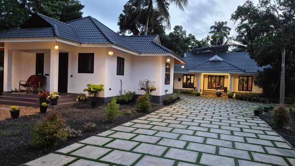 a house with a stone driveway in front of it at Casa Luminaria in Alleppey
