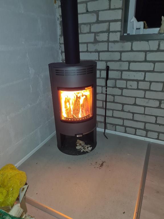 ein Ofen mit einem Feuer darin in einem Zimmer in der Unterkunft Köima Loft in Kõima