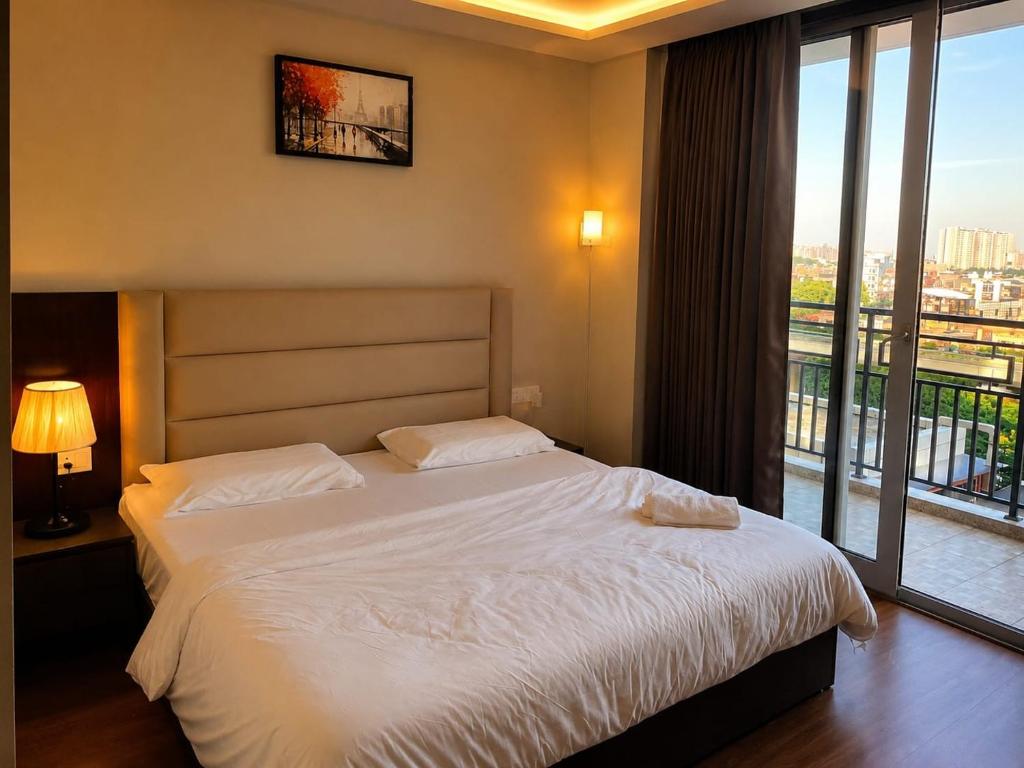 a bedroom with a bed and a large window at Velvet Nook in Greater Noida