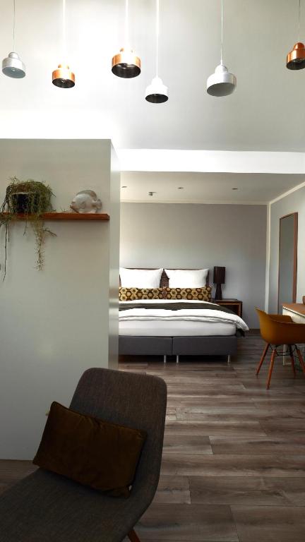 a bedroom with a bed and a chair at Boutique-Hotel "Stilvoll" in Andernach