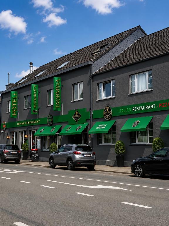 a hotel with cars parked in front of a street at Hotel Taormina Brussels Airport in Zaventem