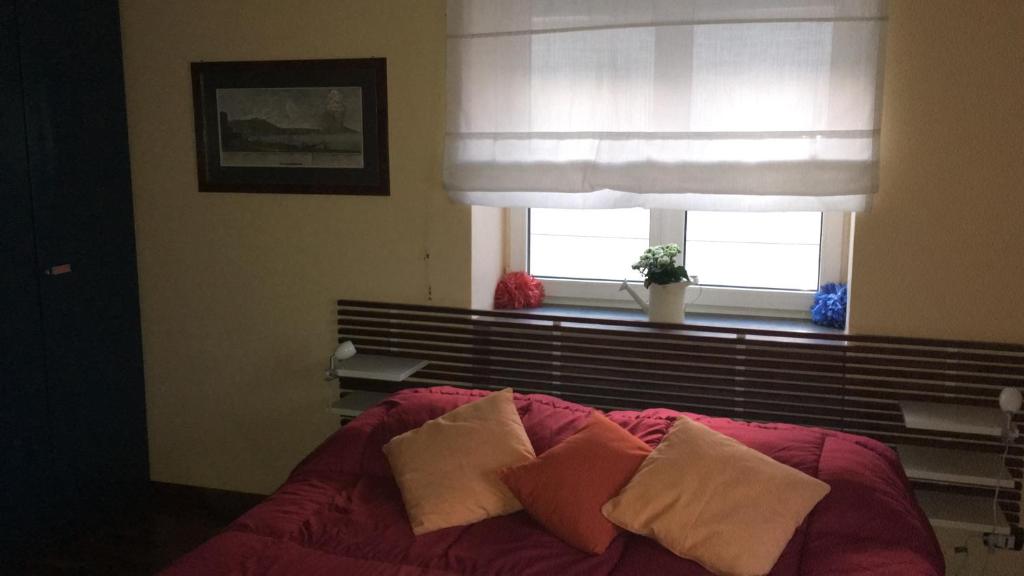 una camera da letto con letto, cuscini e finestra di Toledo Suite a Napoli