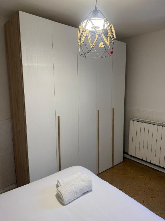 a bedroom with a bed and a chandelier at La Finestra Sul Paese in Pescocostanzo