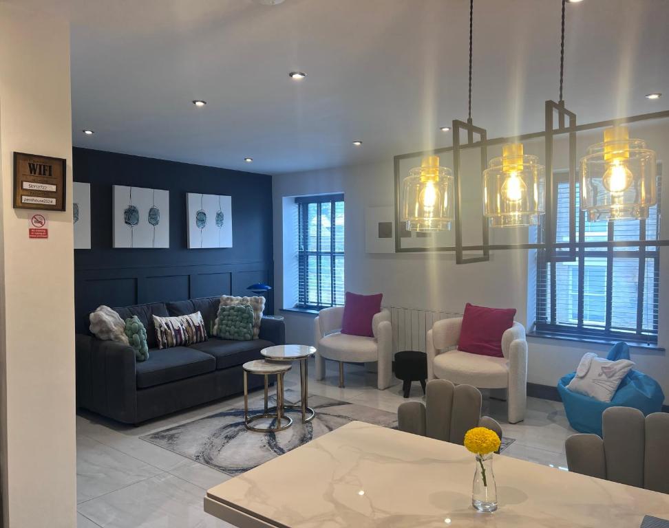a living room with a couch and chairs and a table at The Penthouse Luxury Central Apartment in Glossop