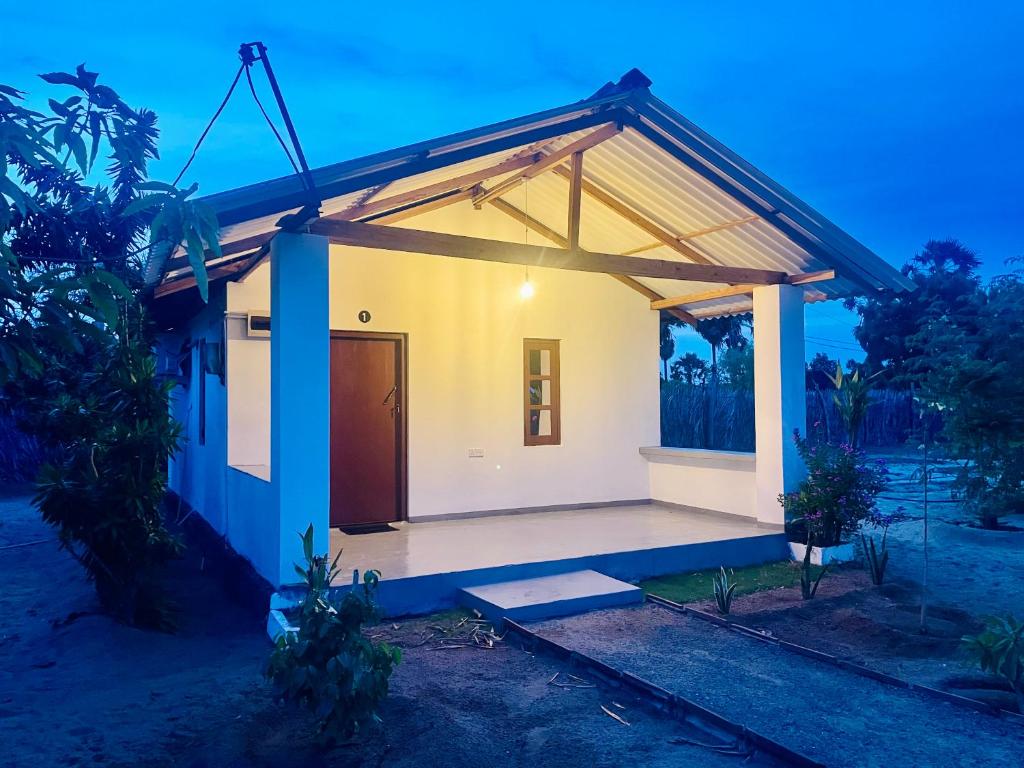 a small house with a large porch at Kora Beach House & Restaurant Cafe in Ampara