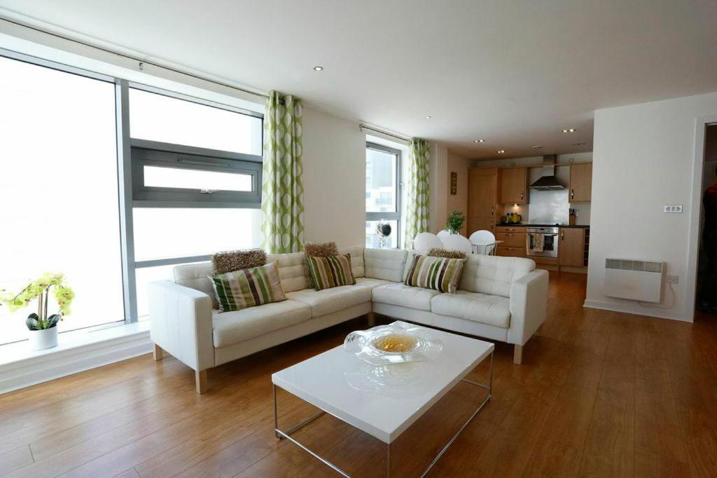 a living room with a white couch and a table at Edinburgh Waterfront Apartments in Edinburgh