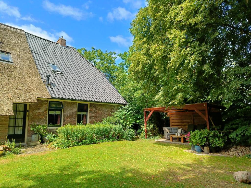 a brick house with a patio and a tree at Voorhuis 2 personen - De Kruidenhoeve in het Reestdal - in Balkbrug