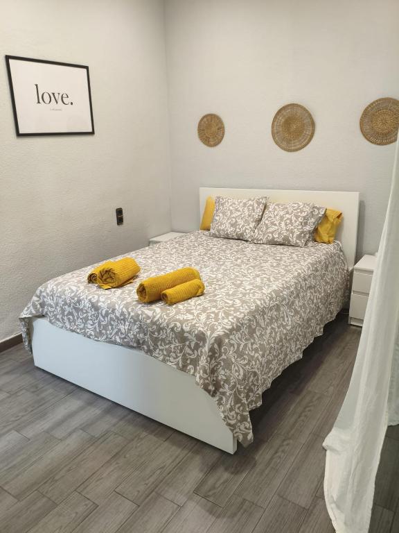 a bedroom with a bed with two yellow pillows at El Molar Loft in El Molar