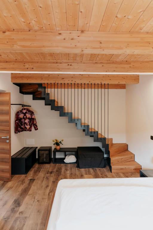 a room with wooden ceilings and a staircase at B&B Piccolo Relais in Lessolo