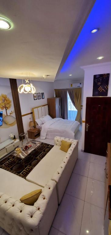 a large bedroom with a large bed and a couch at Luxury studio apartment in Accra