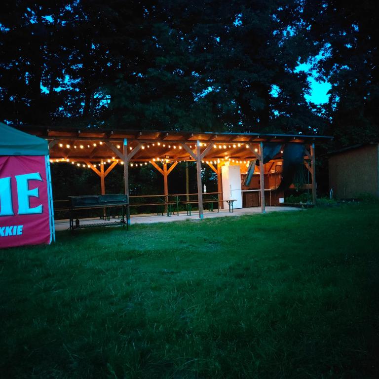 a pavilion with lights on it in a yard at night at Pole namiotowe u Józia in Borne Sulinowo