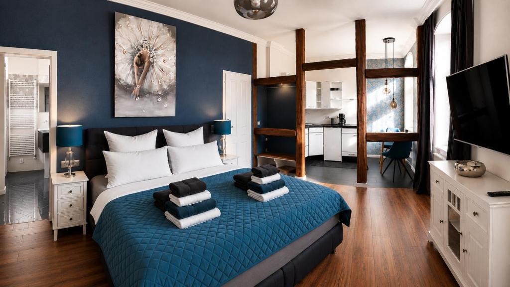 a bedroom with a large bed with blue walls at Apartmenthaus am See - Seeblick Suite - Nähe Motorsportarena in Seehausen
