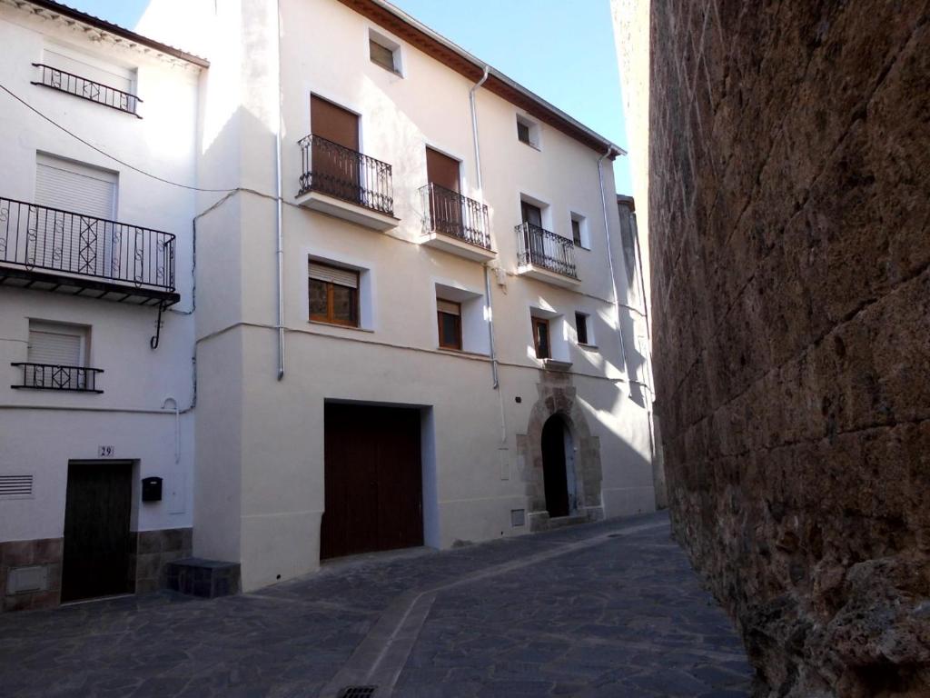 a large white building with balconies on a street at Casa Cardelina in Camporrells
