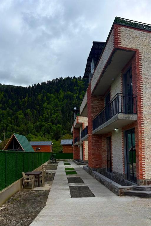 a brick building with a patio and a table at Pine villa sadgeri in Sadgeri