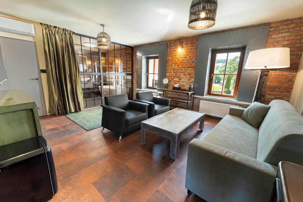 a living room with a couch and chairs and a table at Boutique rooms Fabrika in Děčín