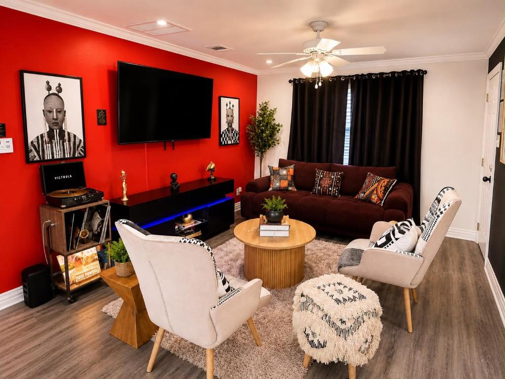 a living room with red walls and a couch at 3BR Houston with Grill, Hot Tub and Game Room near NRG, Downtown and Hobby Airport in Houston
