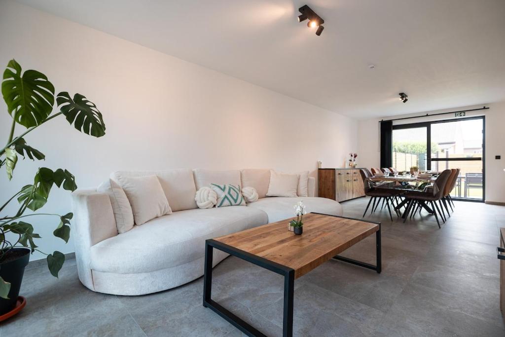 a living room with a white couch and a table at Horse Valley in Tongeren