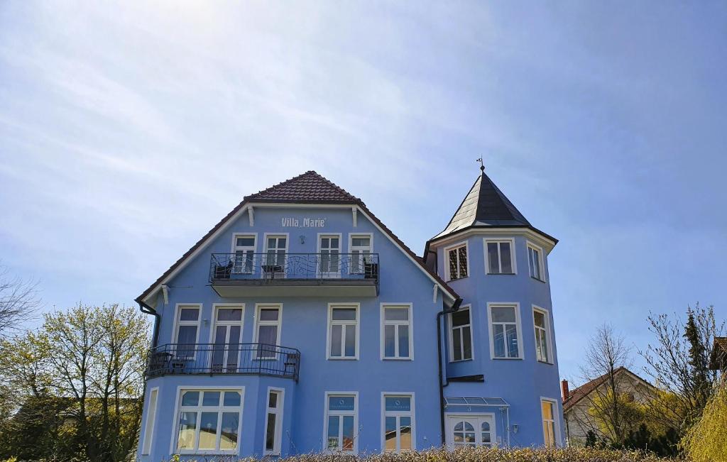 a blue house with a tower and a balcony at Ferienwohnung Ostseeglück in der Villa Marie in Kühlungsborn