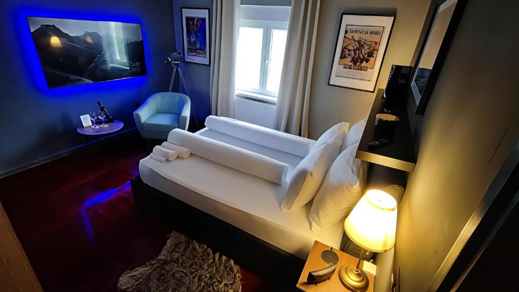 a bedroom with a white bed and a blue wall at Zagora Hills Premium Apartman in Krapina