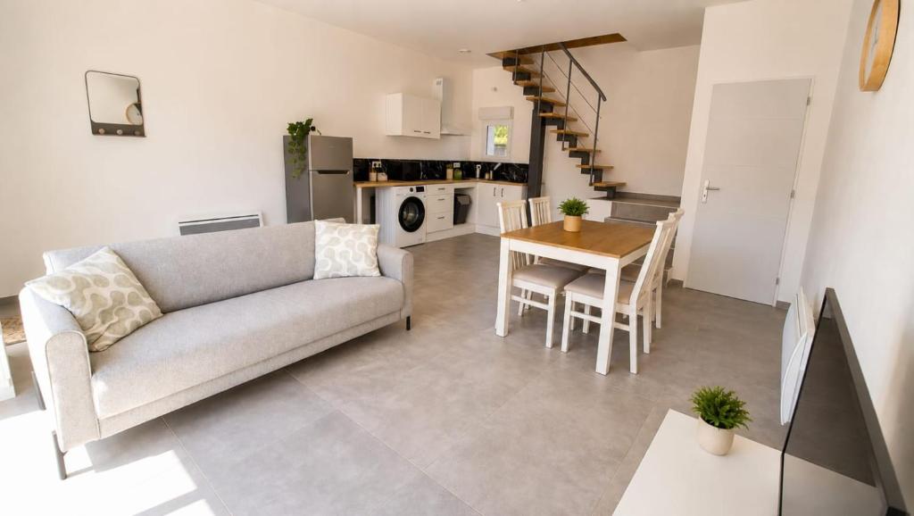 a living room with a couch and a table at Duplex du Paradis 2 chambres in Saint-Romain-de-Jalionas