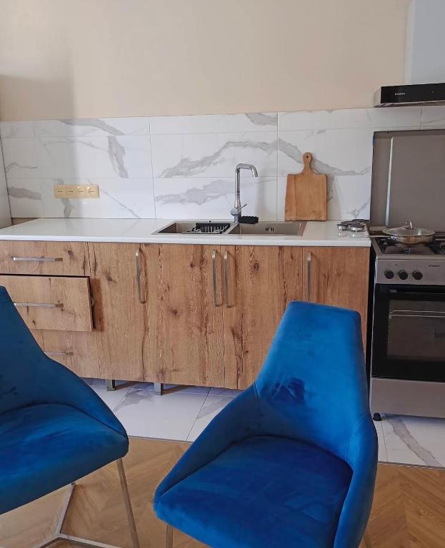 a kitchen with a sink and two blue chairs at temo lali in Tbilisi City