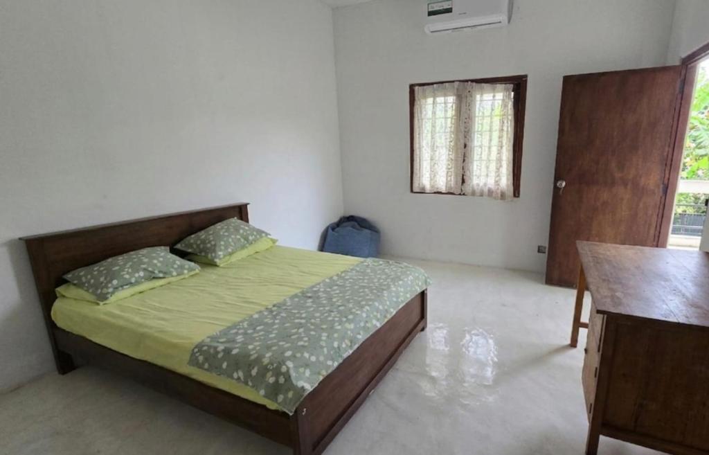 a bedroom with a bed and a desk and a window at Nimna Panadura in Panadura