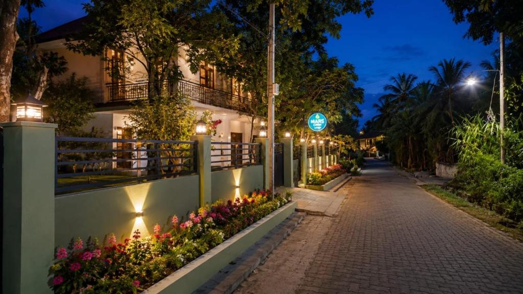 a street at night with flowers and a building at MARS Lodge home stay in Anuradhapura
