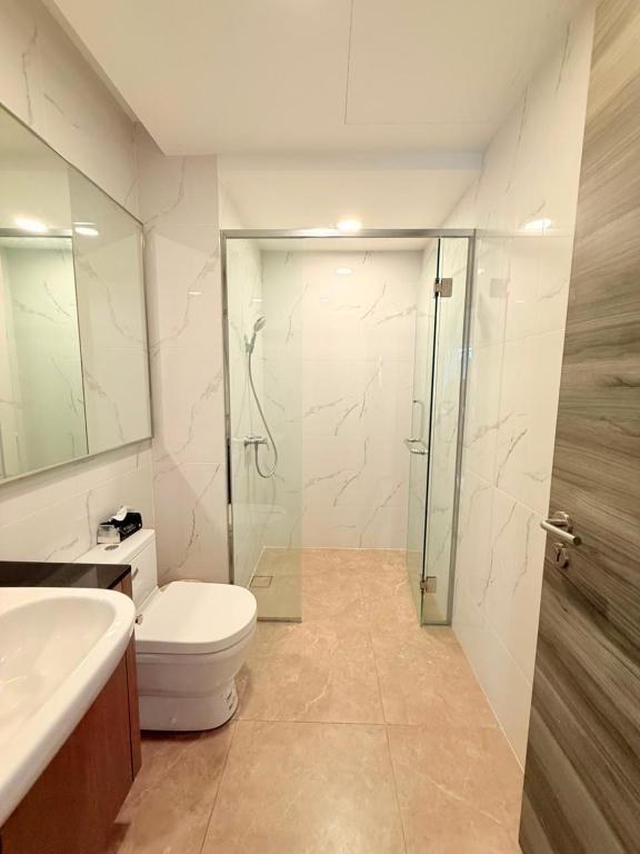 a bathroom with a toilet and a glass shower at Agile Residence By Arshad in Kuala Lumpur