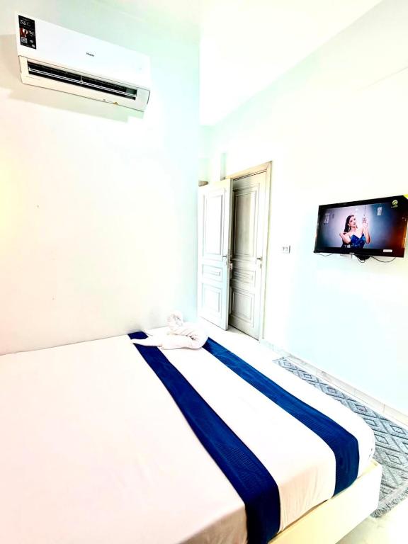 a bedroom with a bed with a tv on the wall at منتجع أمواج الترفيهي in Ras El Bar