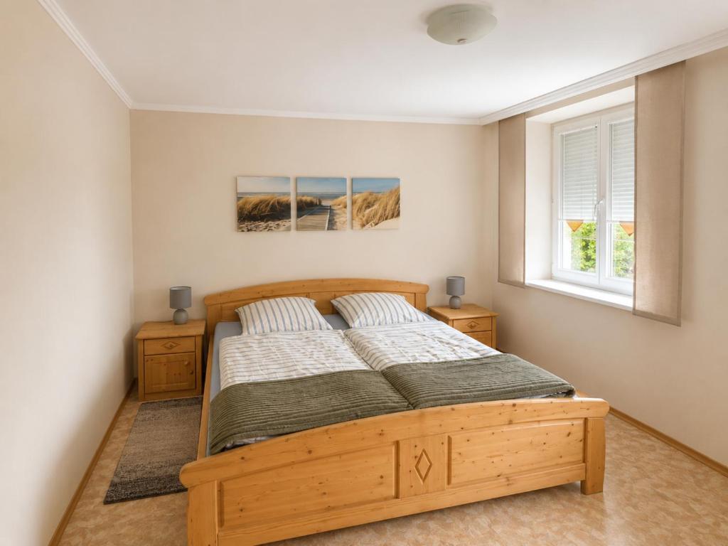 a bedroom with a wooden bed and a window at Ferienwohnung am Arberzentrum in Zwiesel