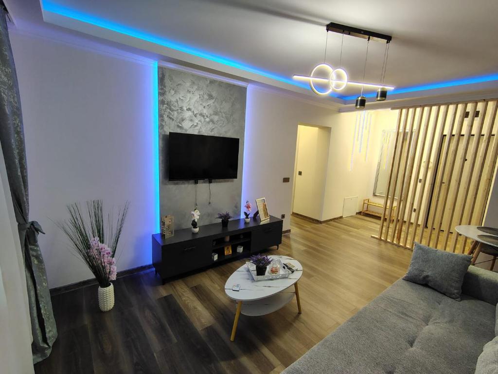 a living room with a couch and a table and a tv at David Apartament in Hunedoara
