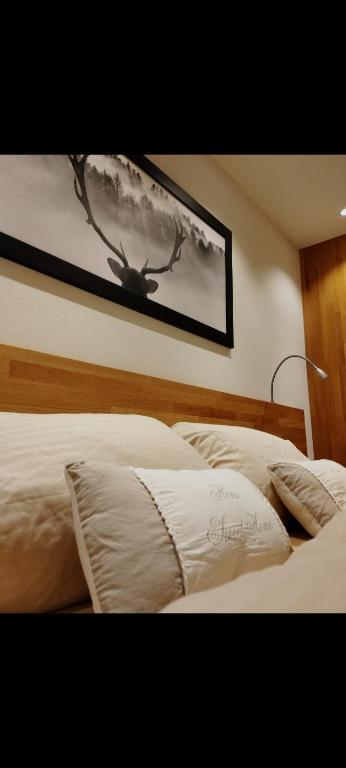 a bed with a picture of a antelope on the wall at FeWo Hirsch in Todtmoos