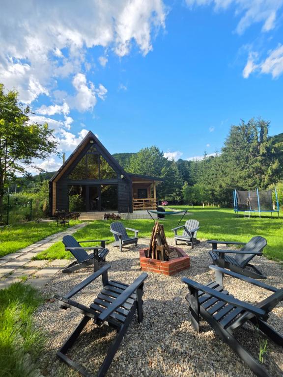 a group of picnic benches in front of a cabin at Cabana ONYX Baile Olanesti in Băile Olăneşti