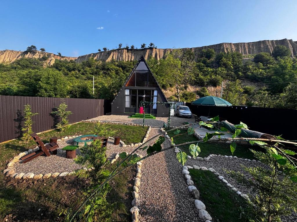 a small house with a mountain in the background at Ren a frame qusar in Qusar