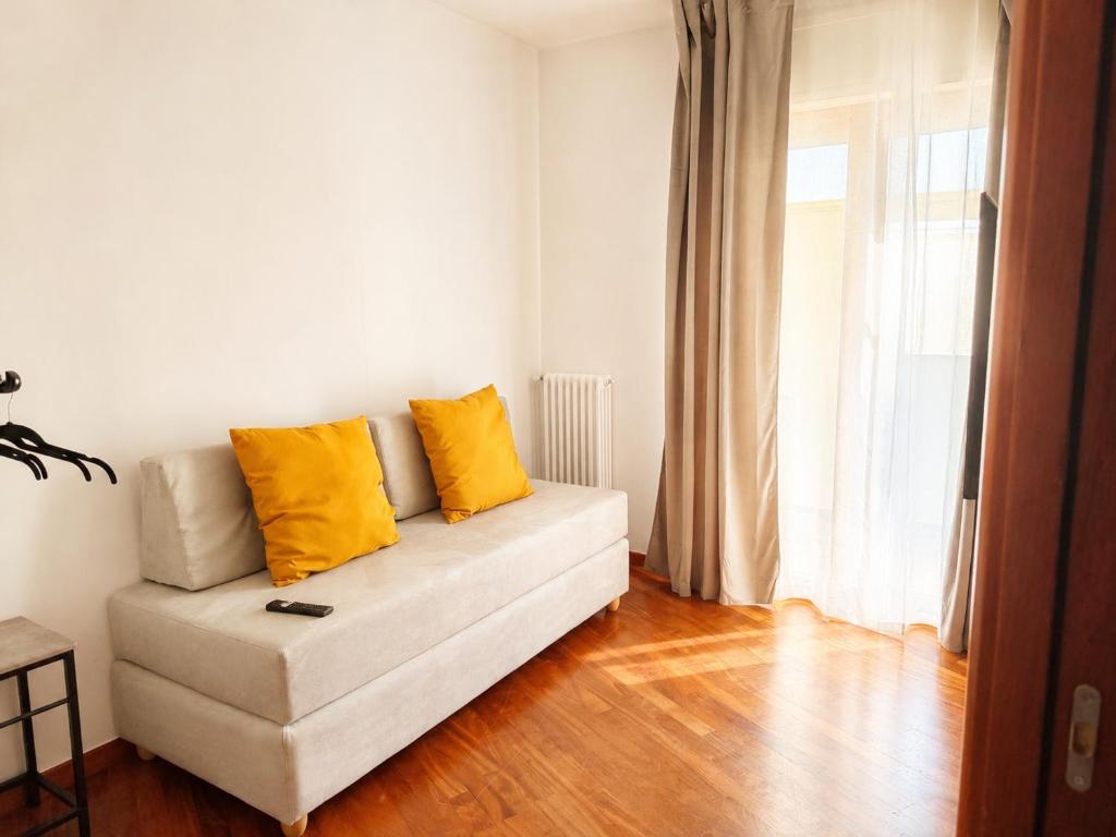 a living room with a couch with two yellow pillows at Del Console Apartment 2 - Near Bari Airport & Station in Modugno