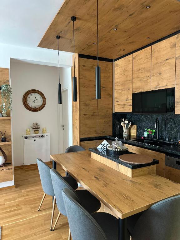 a dining room with a wooden table and chairs at Lux Apartman Leša in Vrdnik