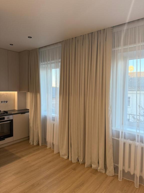 a living room with white curtains and a large window at 2 кімнатні Апартаменти біля Порт Сіті з кондиціонером in Lutsk
