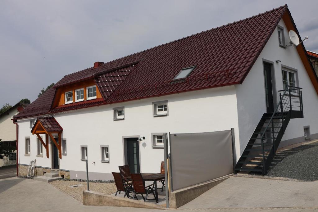a white house with a table and chairs at Ferienoase übern Zottbachtal in Pleystein