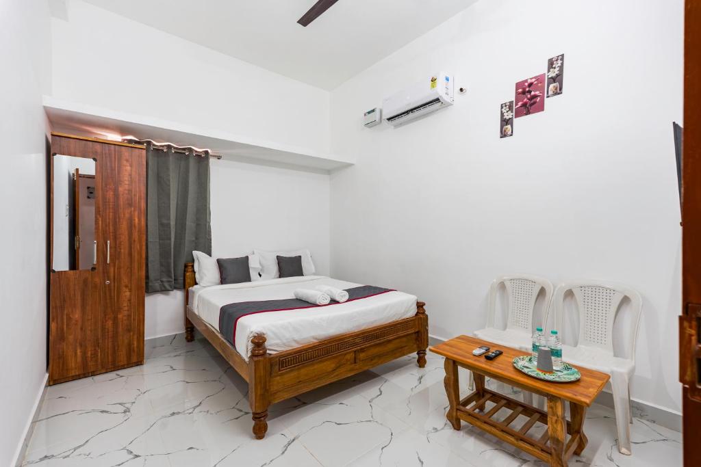a bedroom with a bed and a table in it at B2N Hotels Near Sri Ramachandra Hospital Porur in Chennai