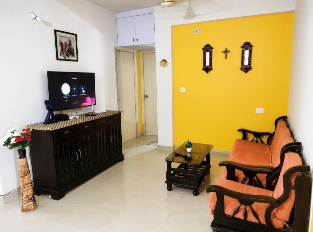 a living room with a tv and a couch and chairs at Regal by the bay in Varca