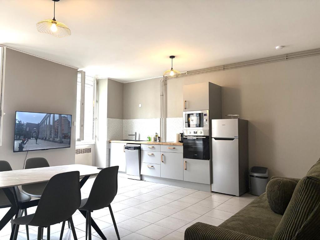 a kitchen and dining room with a table and chairs at Appartement centre-ville Montluel in Montluel