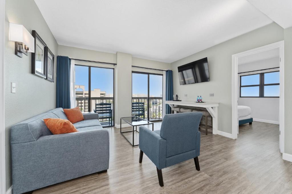 a living room with a couch and a chair and a desk at Lake View Top Floor 2 Bed 2 Bath Condo with Balcony in Orlando