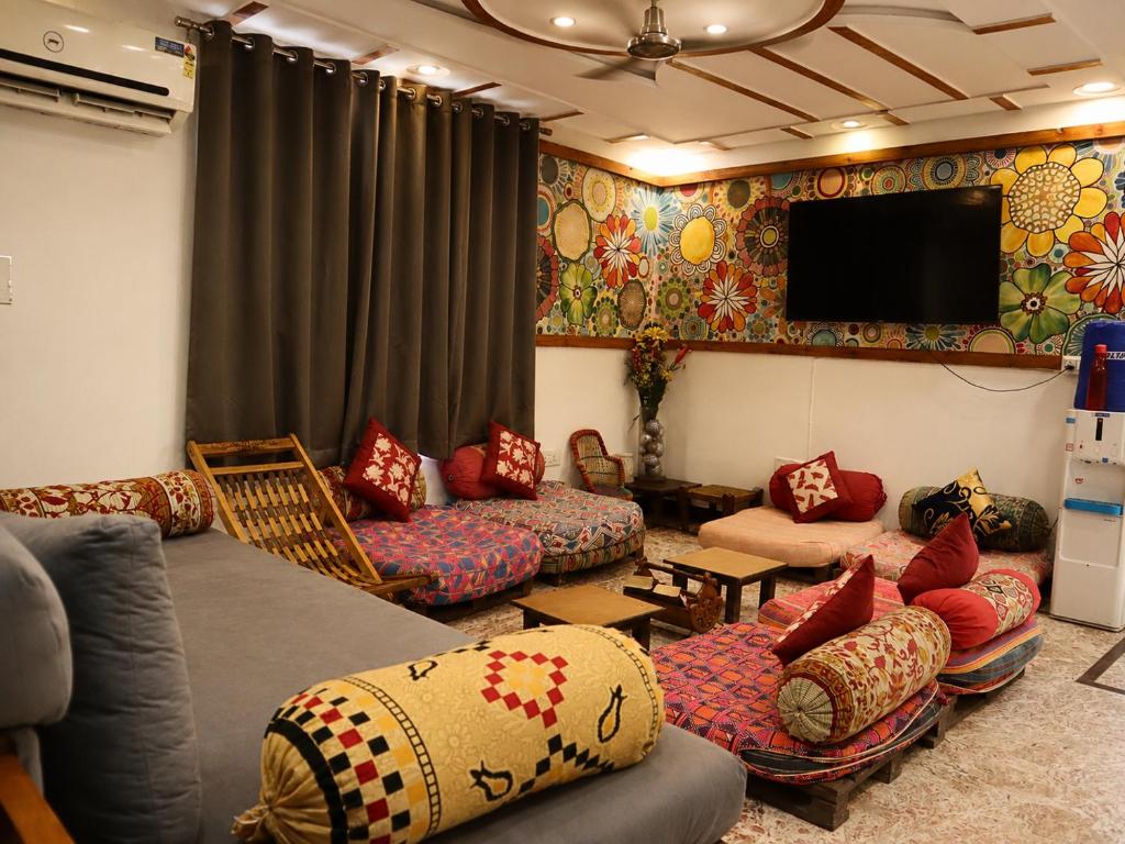 a living room with couches and a flat screen tv at Jungle by sturmfrei Agra in Agra