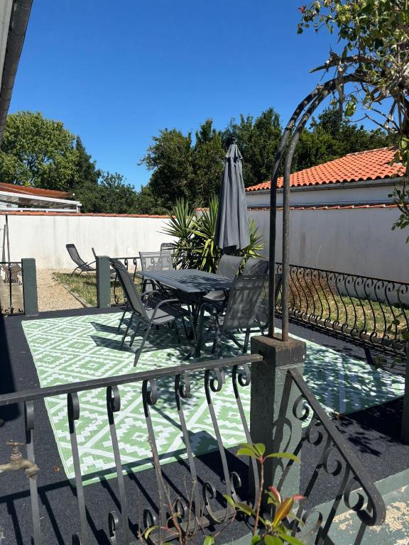 a patio with an umbrella and a table and chairs at Les Belous in La Rochelle