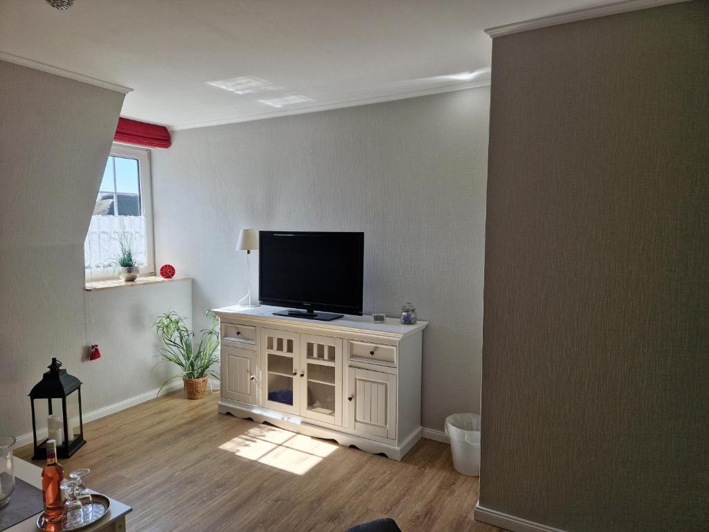 a living room with a flat screen tv on a white cabinet at Suite in Nieblum - Martina Christiansen in Nieblum