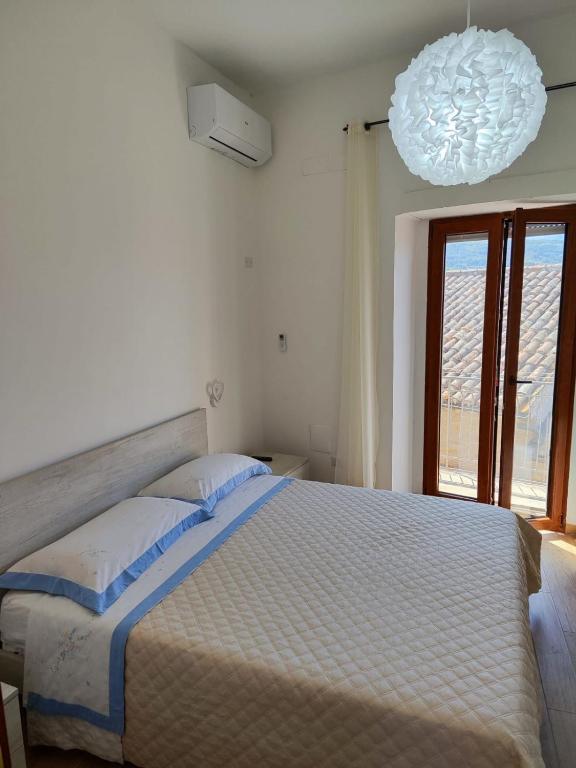 a bedroom with a large bed and a chandelier at A Chera Via in Laureana Cilento